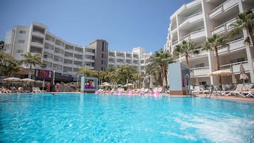 Una piscina al aire libre, sombrillas, tumbonas