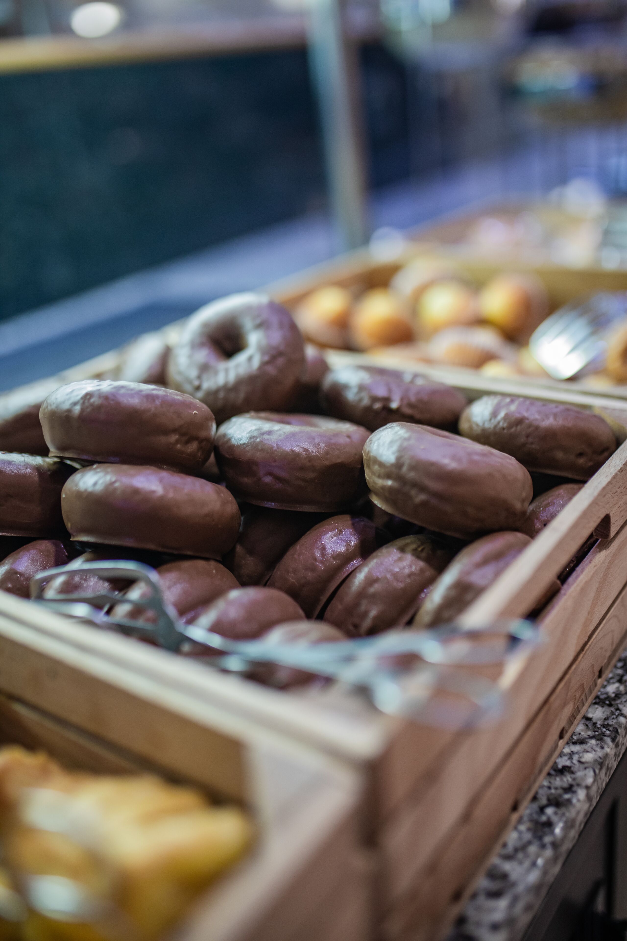 Ein Holztablett mit verschiedenen Backwaren, darunter Donuts und anderem Gebäck.