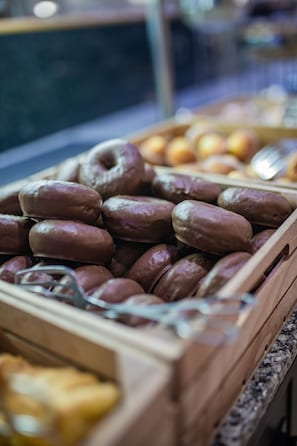 A wooden tray filled with various pastries, including donuts and other baked goods.