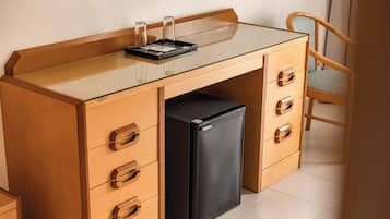 Eine kleine Küche mit einer Esstischplatte aus Glas, einem schwarzen Kühlschrank und Holzschränken.
