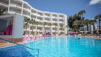 Una piscina al aire libre, sombrillas, tumbonas