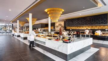 Uma área de buffet com balcões de mármore e um lustre moderno.