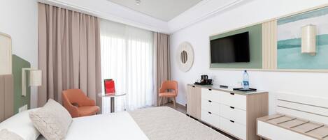Habitación de hotel con una cama grande, un escritorio, una silla, un televisor y un cuadro en la pared.