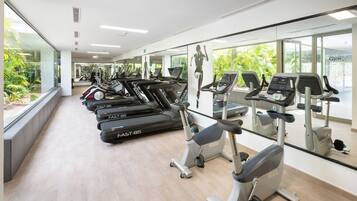 A gym with treadmills, stationary bikes, and elliptical machines.