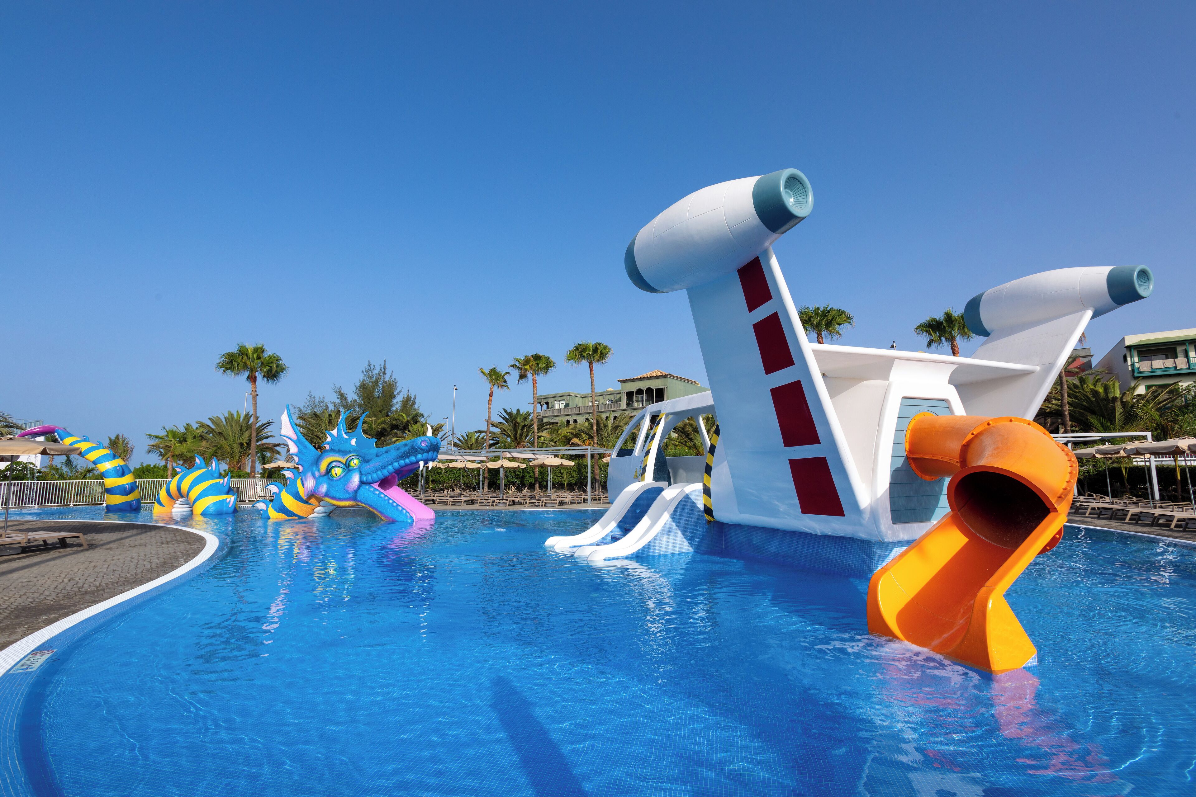 A swimming pool with slides and inflatable structures.