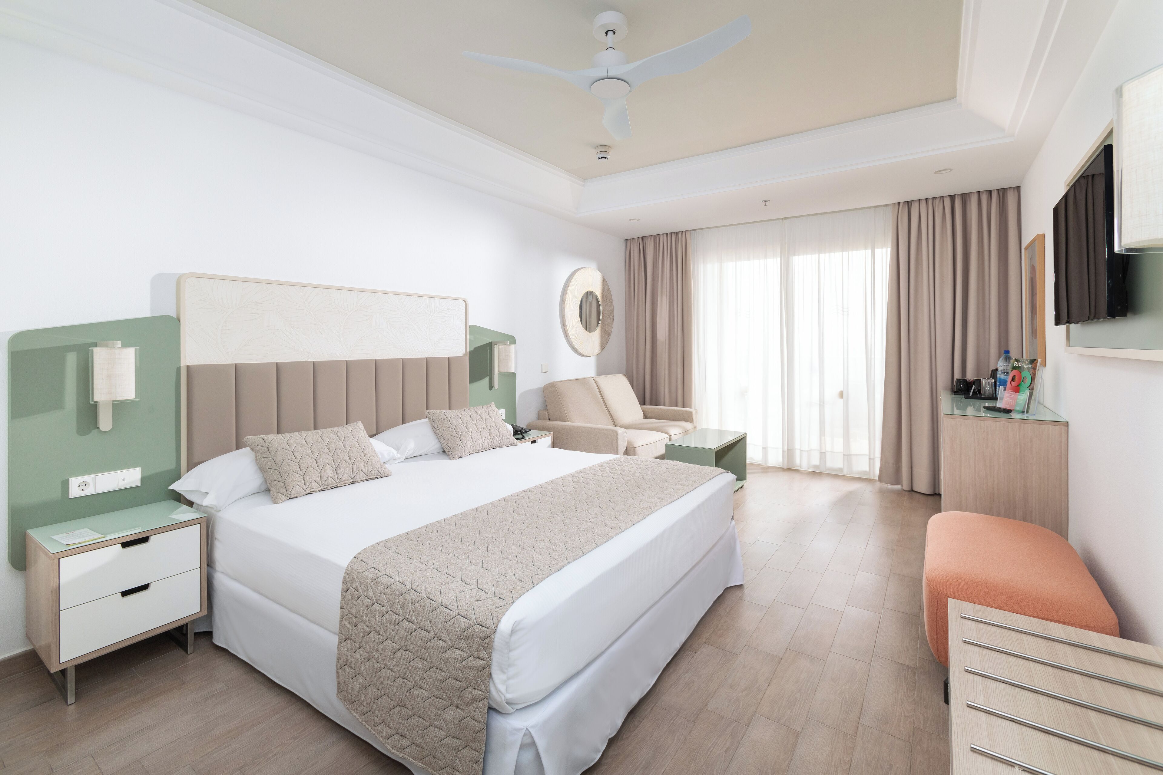 Habitación de hotel moderna con una cama grande, un escritorio, una silla y un televisor.