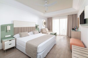 Habitación de hotel moderna con una cama grande, un escritorio, una silla y un televisor.