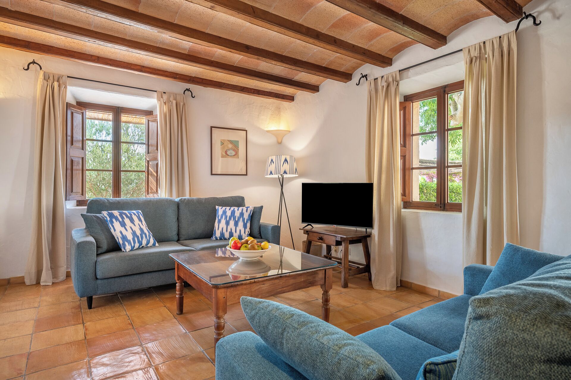 A living room with a sofa, a coffee table, a TV, and a lamp.
