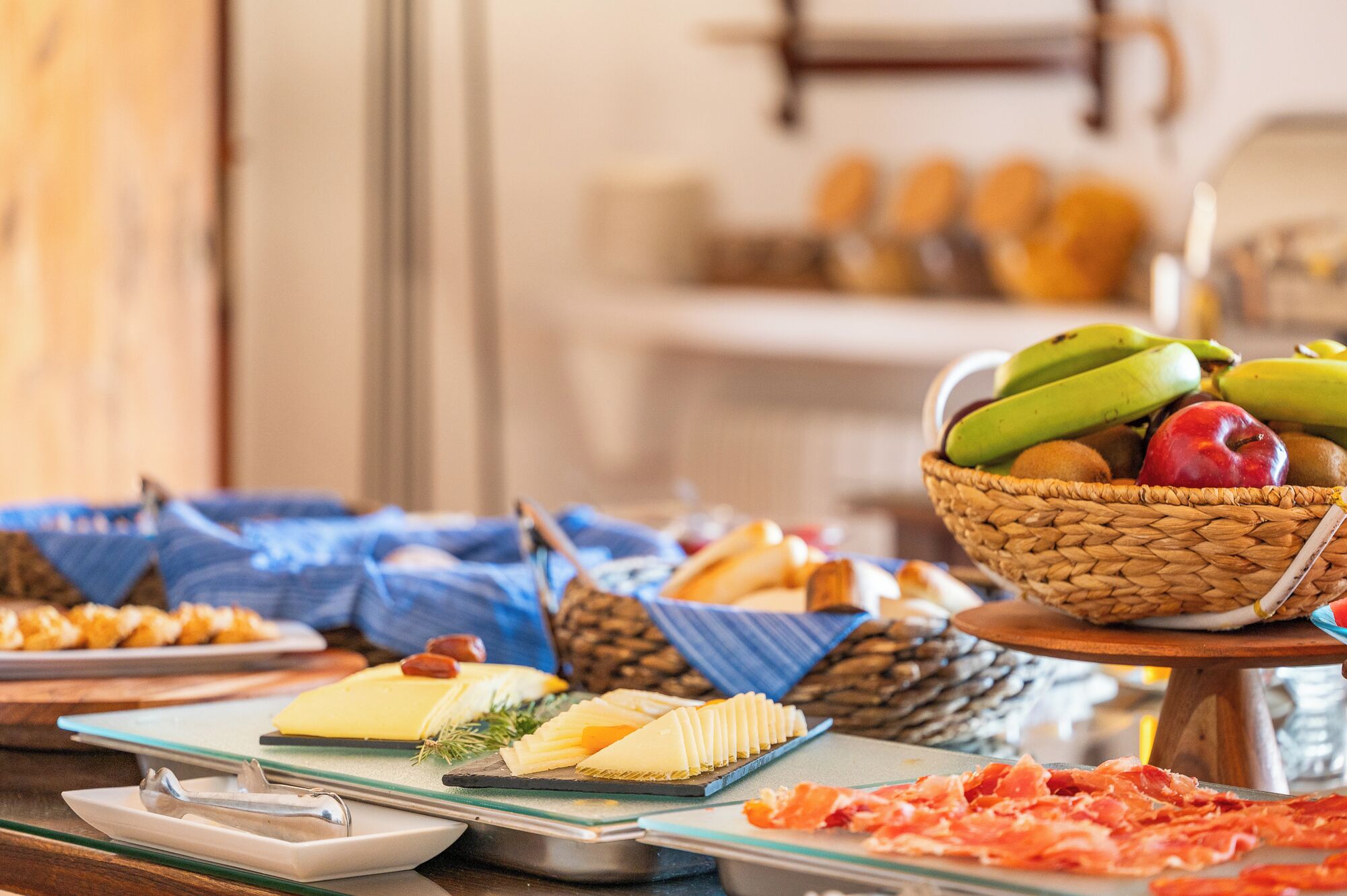 A buffet with various food items including cheese, fruits, and meats.