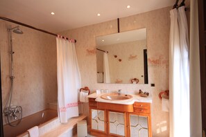 Junior suite, balkon | Badkamer | Een bad/douchecombinatie, gratis toiletartikelen, een haardroger