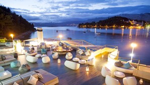 Eine Terrasse am Wasser mit moderner Sitzgelegenheit und Blick auf das Meer.