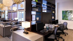 Un espace de bureau moderne comprenant un bureau, un ordinateur, des chaises et une bibliothèque.