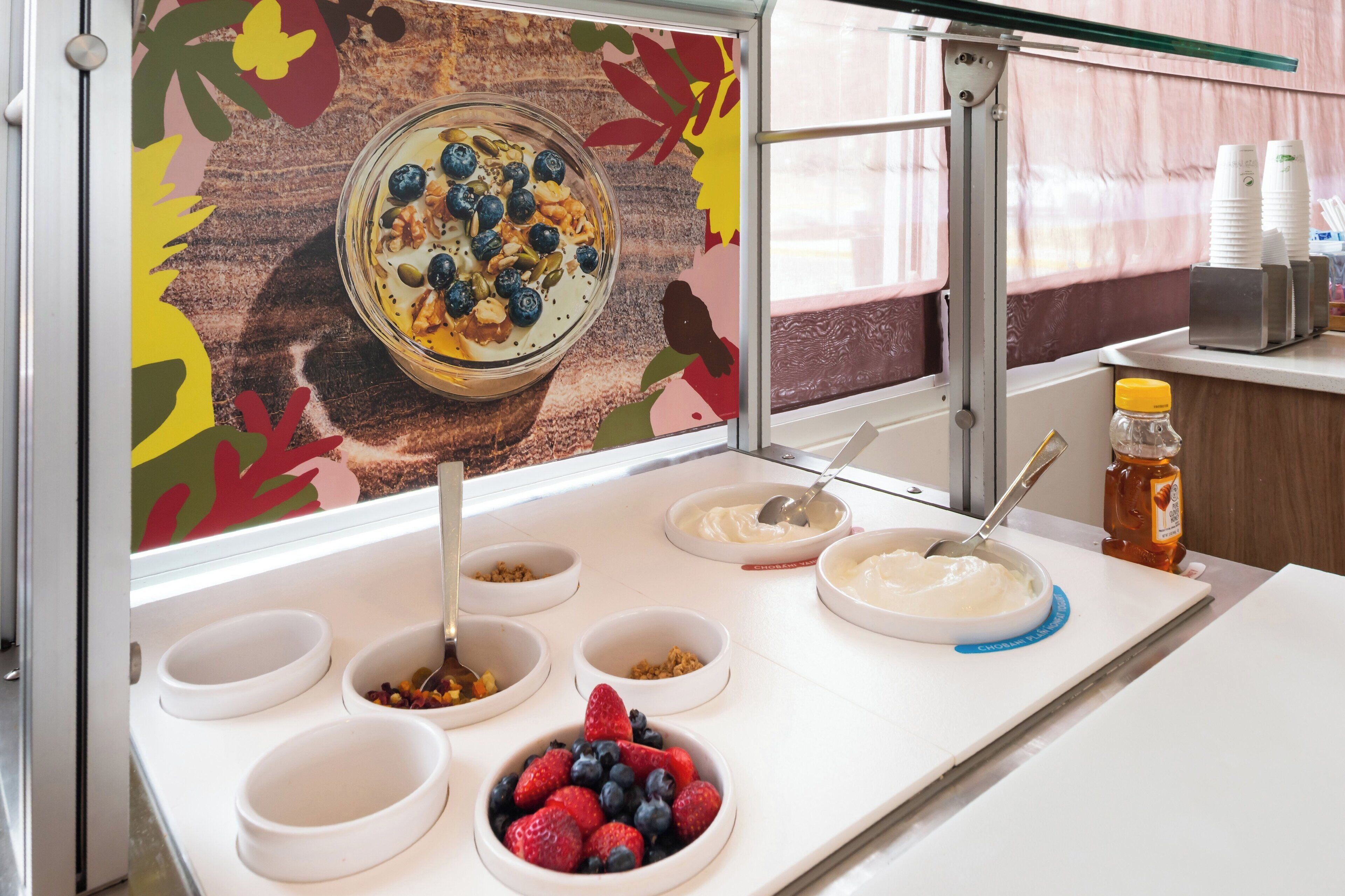 A breakfast buffet with various food items and a decorative wall.