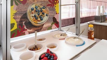A breakfast buffet with various food items and a decorative wall.