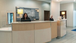 A hotel reception desk with a modern design, a digital screen, and a sign indicating the hotel's name. - Holiday Inn Express & Suites Trinidad by IHG (Trinidad)