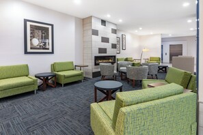 A hotel lobby with green upholstered sofas, a fireplace, and a modern tiled wall. - Holiday Inn Express & Suites Trinidad by IHG (Trinidad)