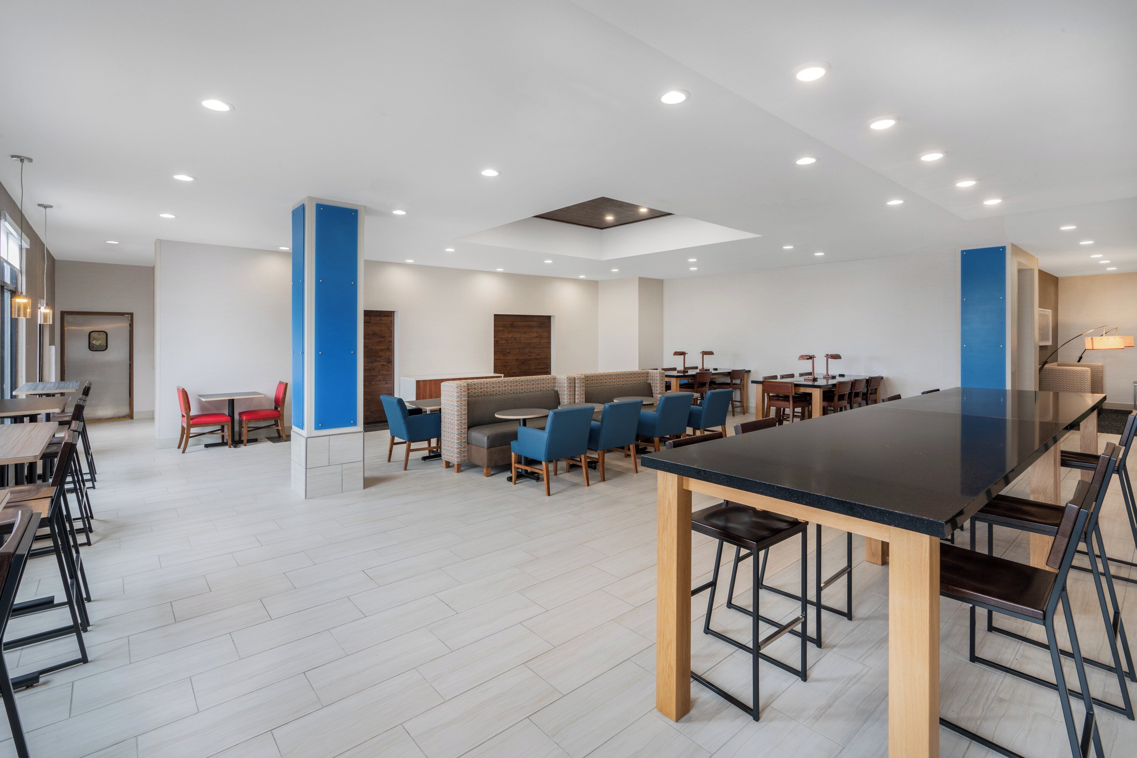 A modern dining area with multiple seating options, including booths and tables, and a central bar area.