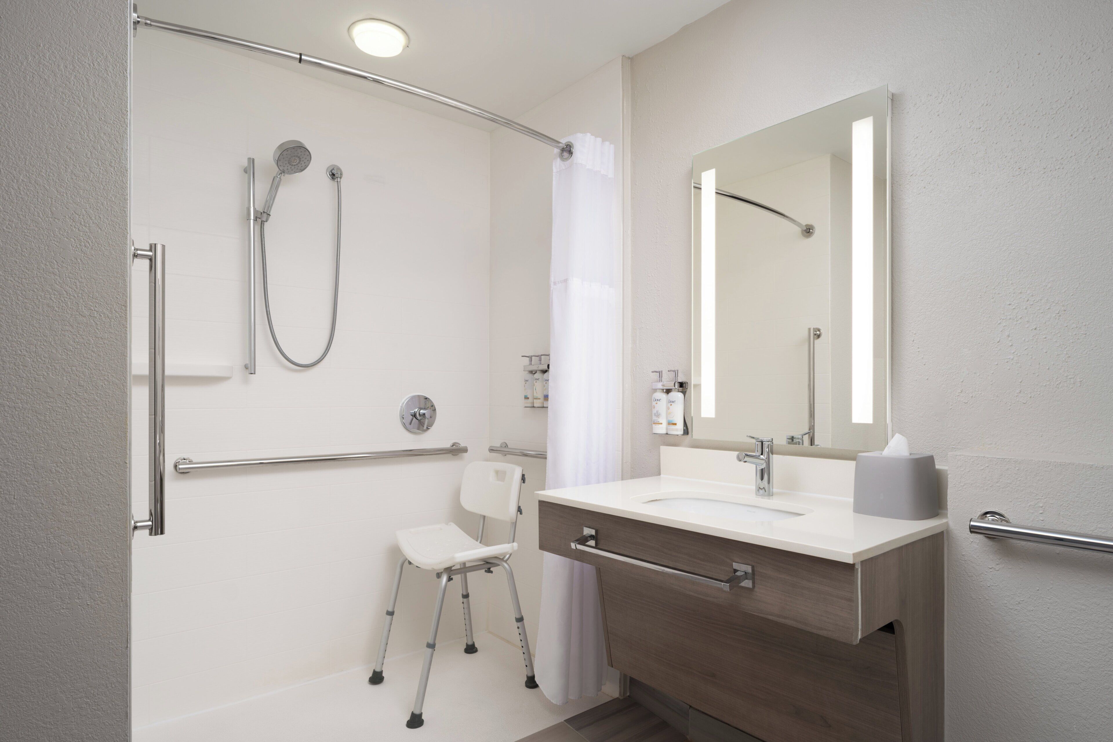 A modern bathroom with a shower, a toilet, and a sink.