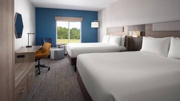 A hotel room with two beds, a desk, a chair, and a view of the outdoors.