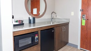 A compact kitchen with a microwave, dishwasher, and sink.