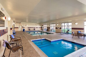 Una piscina techada, sillones reclinables de piscina