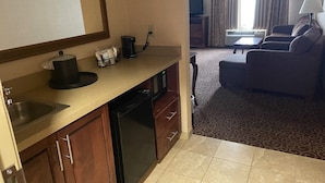 A compact hotel room with a kitchenette, a dining area, and a living space. - Hampton Inn Rawlins (Rawlins)