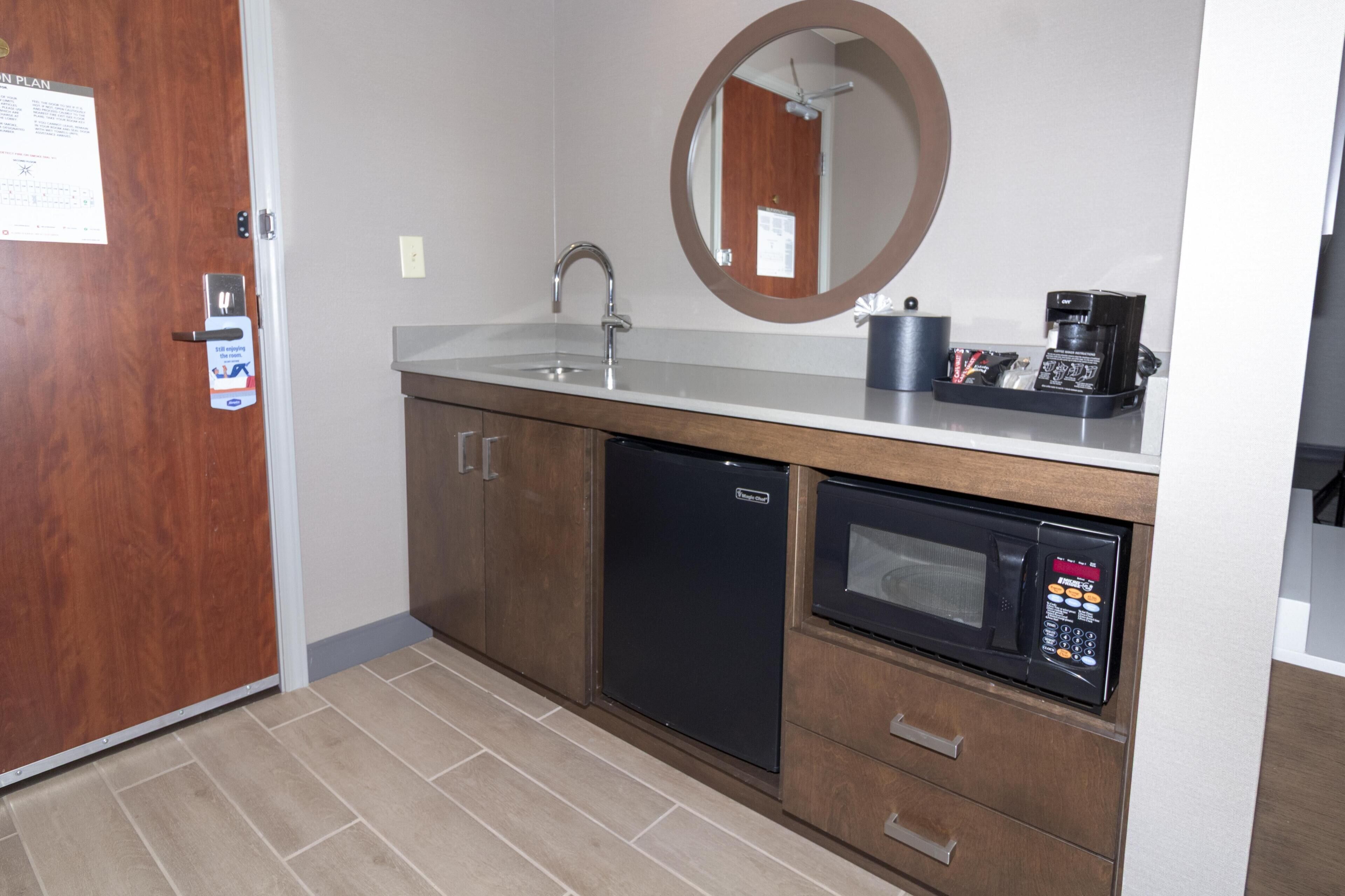 A compact kitchenette with a sink, a microwave, and a coffee maker.