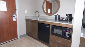 A compact kitchenette with a sink, a microwave, and a coffee maker.