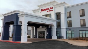 A Hampton Inn by Hilton building with a clear entrance, a sign indicating a 14-foot clearance, and a welcoming sign. - Hampton Inn Rawlins (Rawlins)