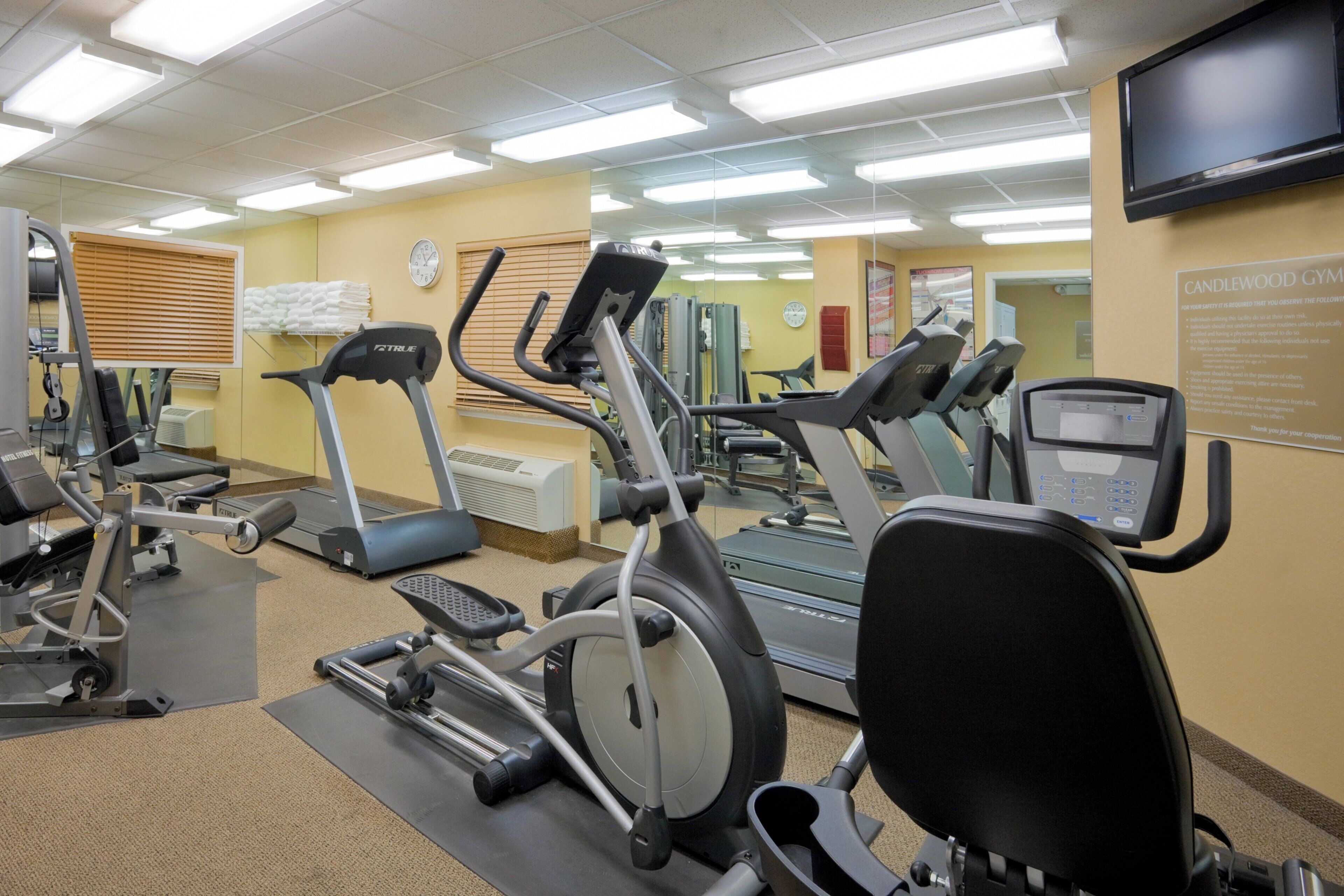 A gym with treadmills, stationary bikes, and exercise equipment.