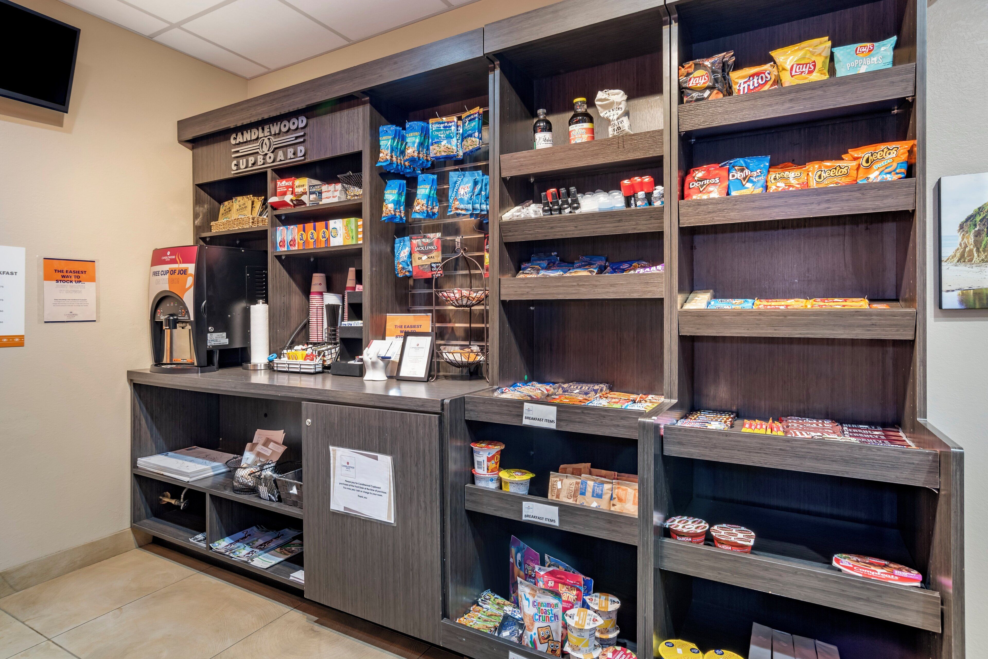 A self-service breakfast area with various food items and a coffee machine.