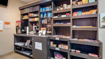 A self-service breakfast area with various food items and a coffee machine.
