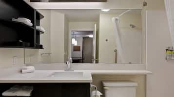 A modern bathroom with a white sink, a mirror, a toilet, and a shower area.