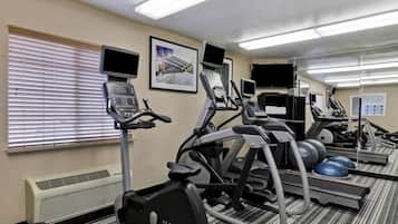 Une salle de sport équipée de nombreux appareils d’exercice, notamment des tapis de course et des appareils elliptiques, ainsi que d’une variété de matériel de remise en forme.