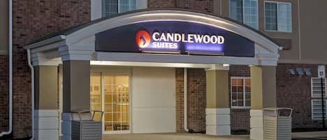 A hotel entrance with a sign reading 'CANDLEWOOD SUITES'.