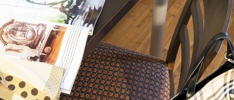 A brochure on a table, a patterned chair, and a handbag.