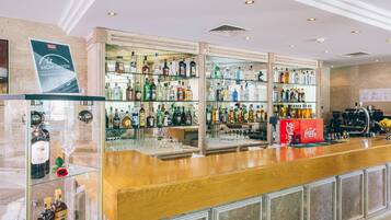 A bar area with a wooden counter and glass display cases filled with various liquor bottles.