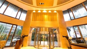 A hotel lobby with a revolving door, large windows, and a reception desk. - Swissotel Foshan (Foshan)