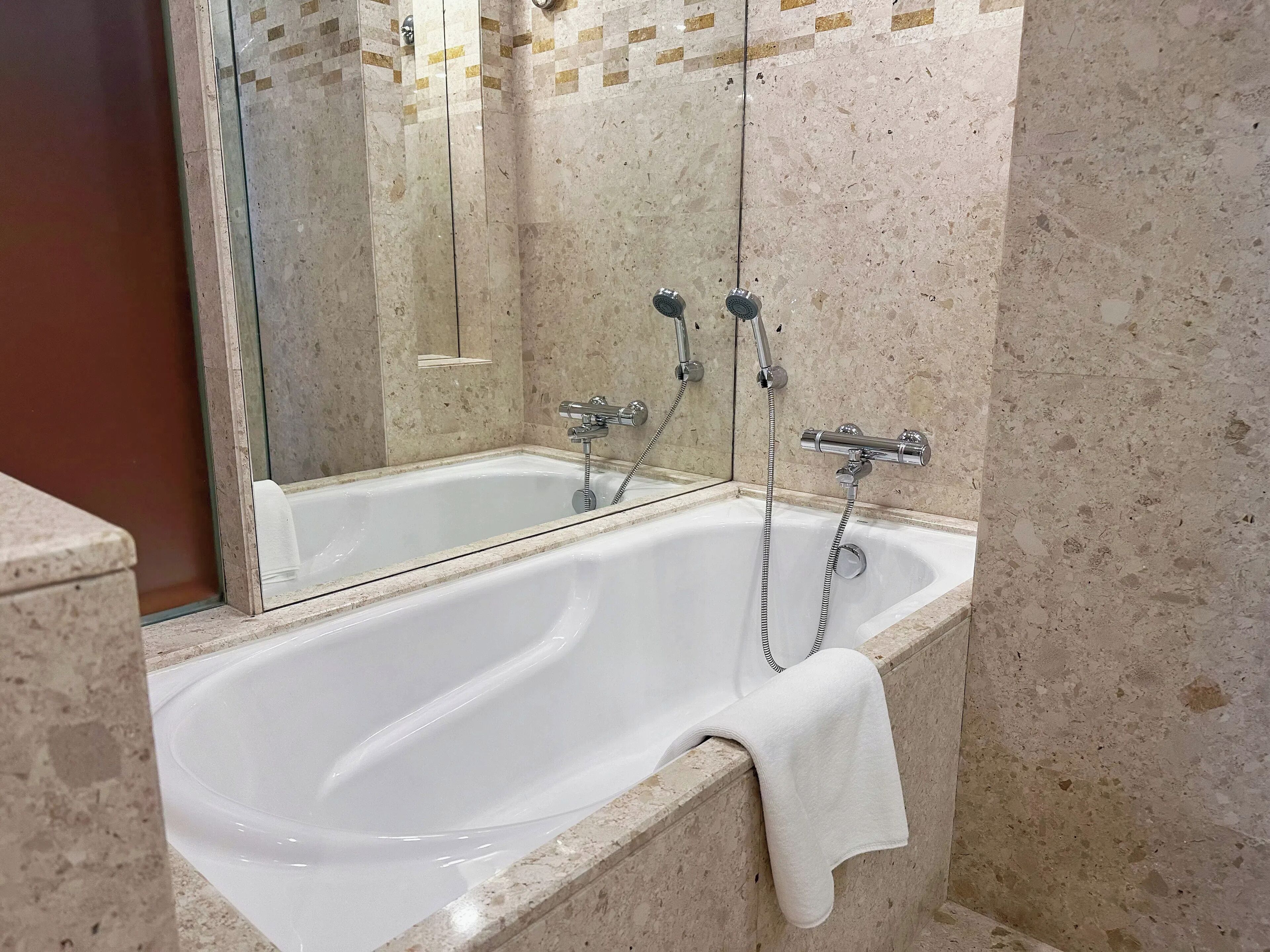 Un baño con bañera, ducha y espejo.