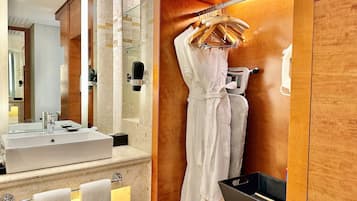 Une salle de bain moderne avec un grand miroir, un lavabo et un porte-peignoir.