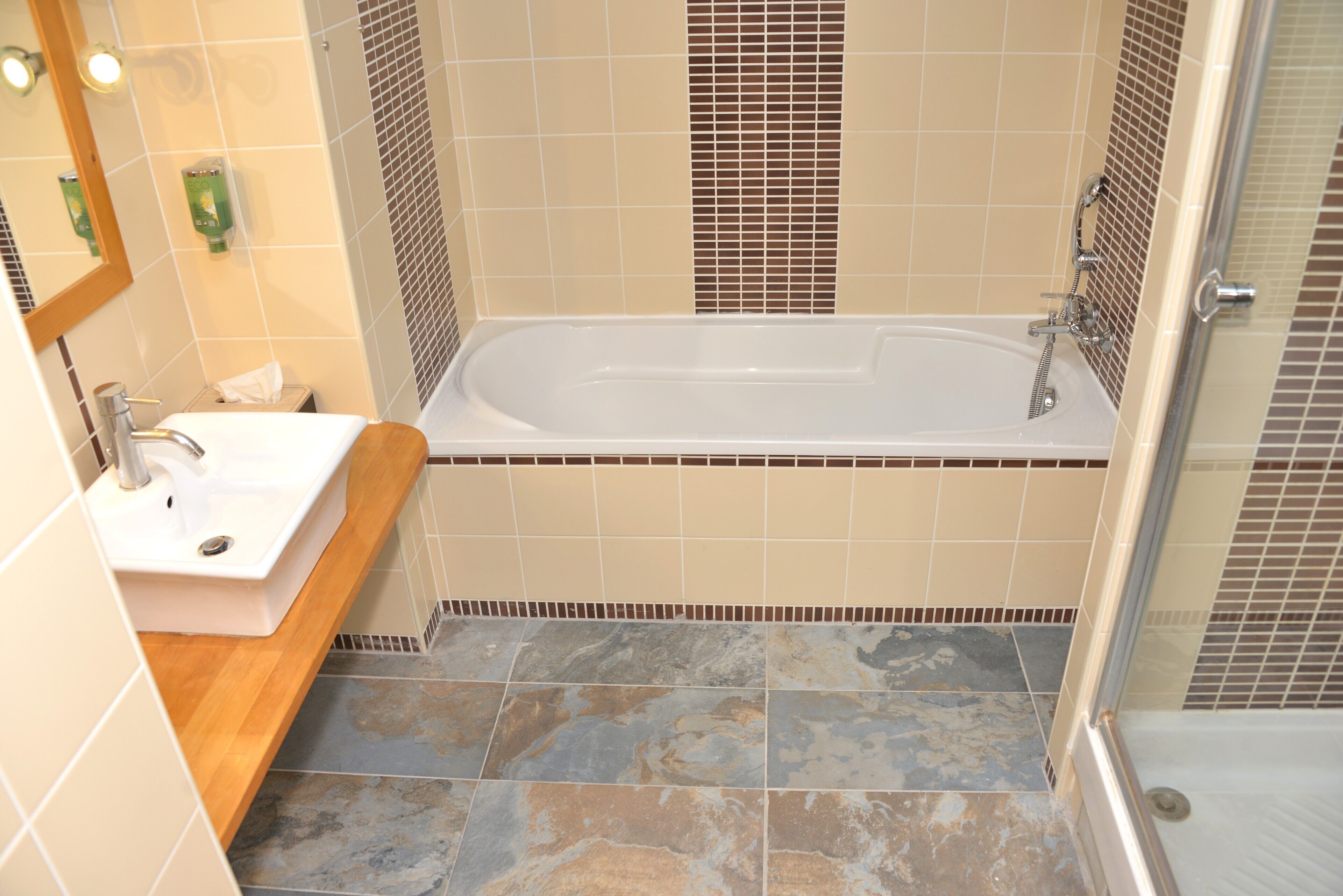 A bathroom with a bathtub, a sink, and a mirror.