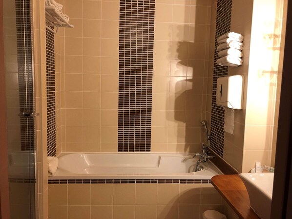 A bathroom with a bathtub, a shower, and a toilet. - Domaine Golf Albon (Albon)