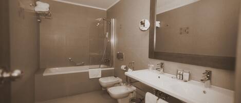 Un baño con bañera, inodoro, bidé y lavabo.