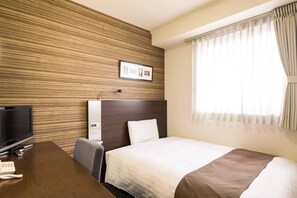 A hotel room with a wooden wall panel, a bed with a white and brown bedspread, a desk with a television and telephone, and a window with curtains. - Comfort Hotel Kumamoto Shinshigai (Kumamoto)