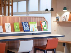 Un espace de travail moderne avec un bureau en bois, cinq livres et deux chaises.