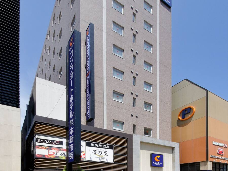 A tall hotel with multiple floors, a Comfort hotel sign, and a restaurant with a 'Candle' sign.