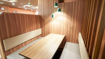 A modern interior with wooden panel walls, a central table, and bench seating.