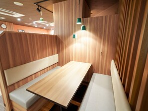 A modern interior with wooden panel walls, a central table, and bench seating.
