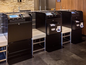 A row of self-service kiosks with card readers and a cash dispenser, likely for check-in or payment processing. - Comfort Hotel Kumamoto Shinshigai (Kumamoto)