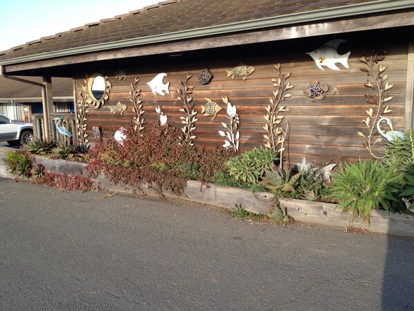 A building with a wooden exterior and decorative fish and plant cutouts.